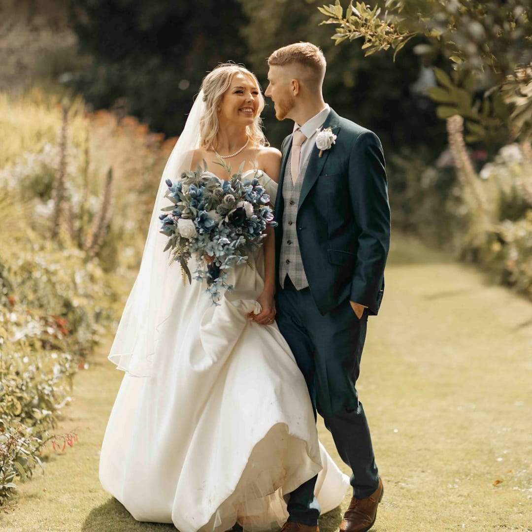 Novios paseando por un jardín el día de su boda