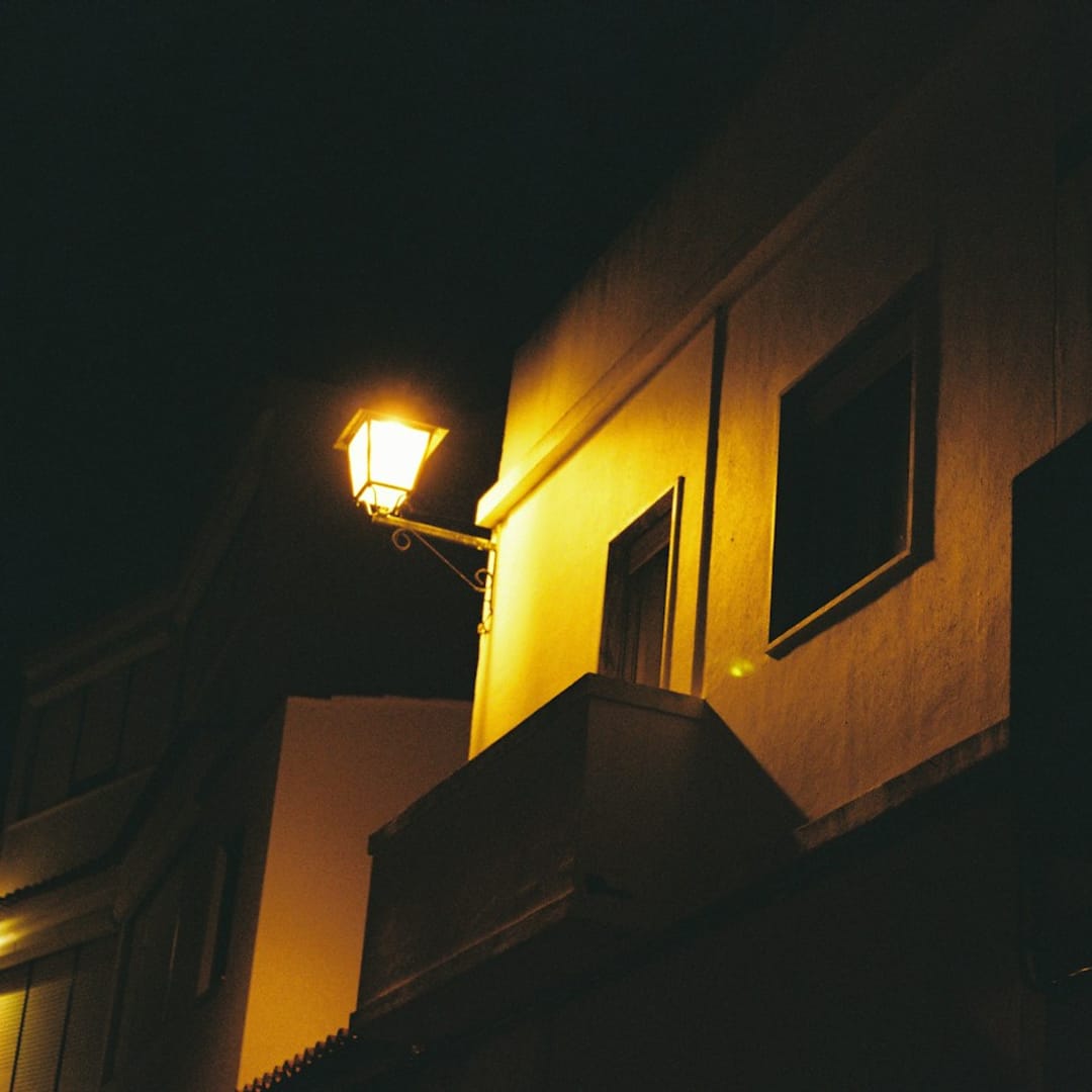 Fachada iluminada por una farola de noche, ambiente de serenata